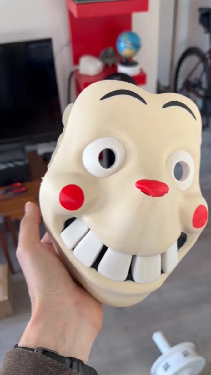 Cream 3D-printed cartoon mask with red nose and cheeks, black eyebrows and a big white toothy grin