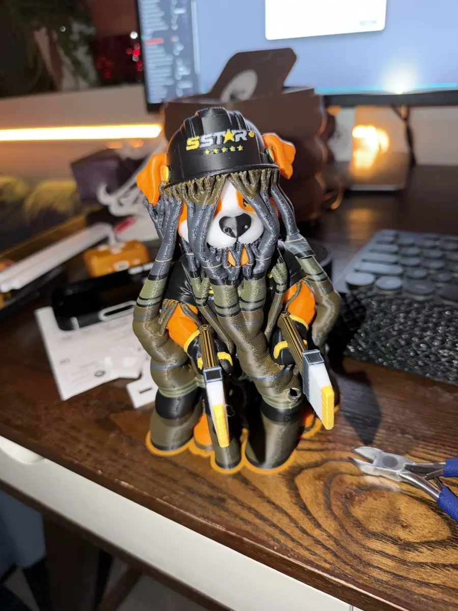 The dog mascot fresh from the printer, wrapped in tree-like support structures before cleanup