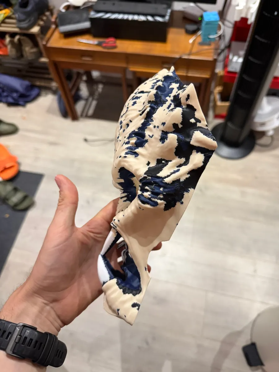 Side view of the printed Predator mask showing navy and black camouflage printed into the cream surface